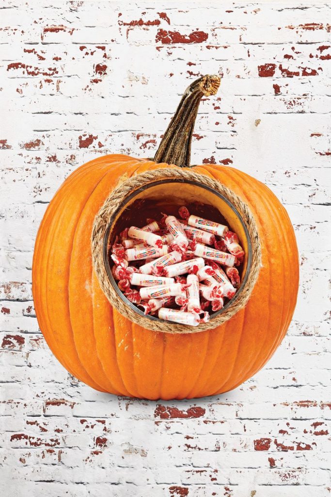 A lot of candy inside of a pumpkin 